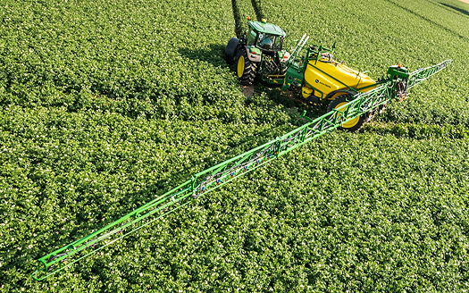 A John Deere M900i Series trailed sprayer equipped with the BoomTrac automatic boom levelling and height control system, which is now available on the mid-specification M700 and M900 Series models.