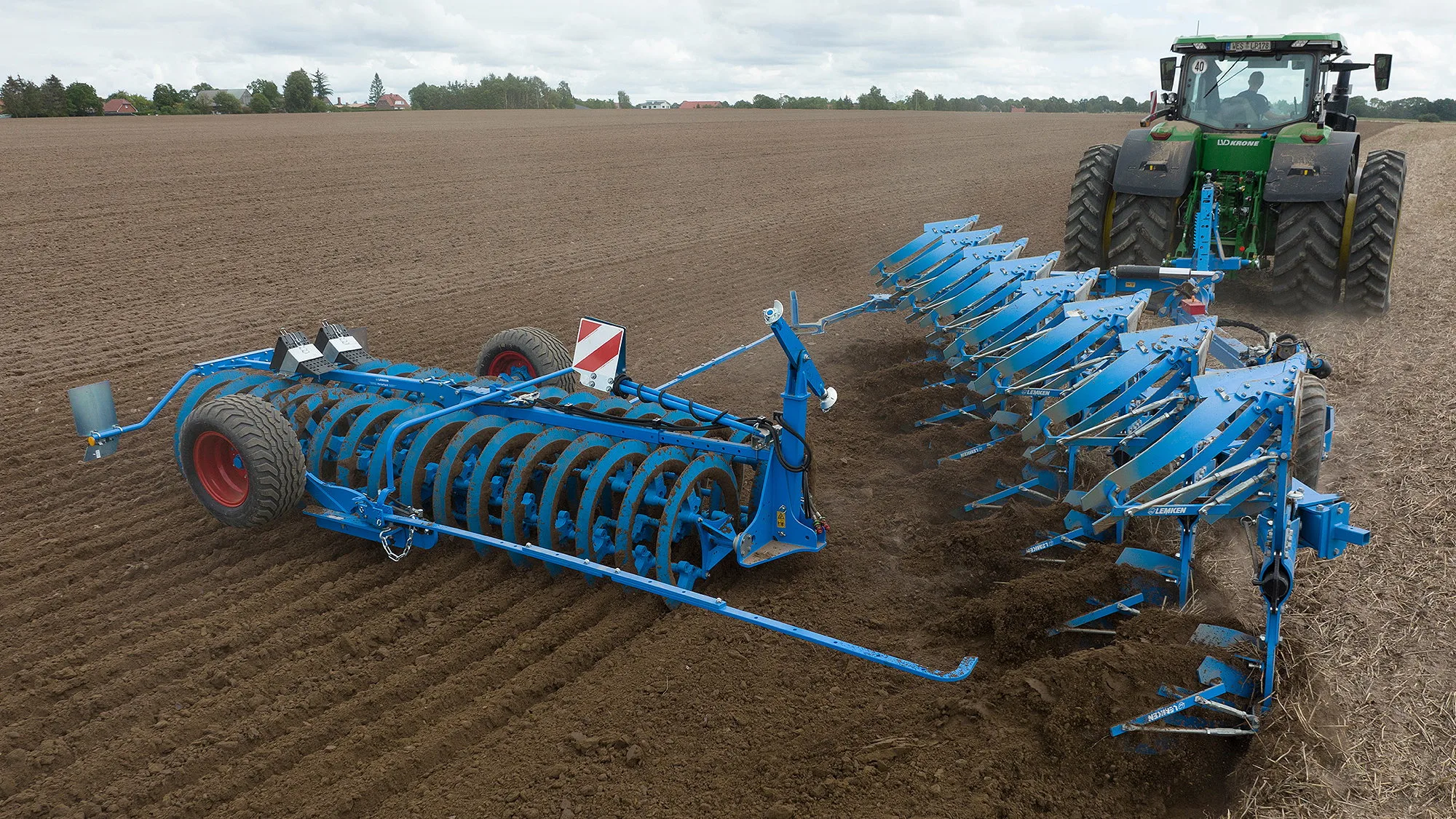 A Lemken VarioPack press working with a semi-mounted Diamant 16 plough.