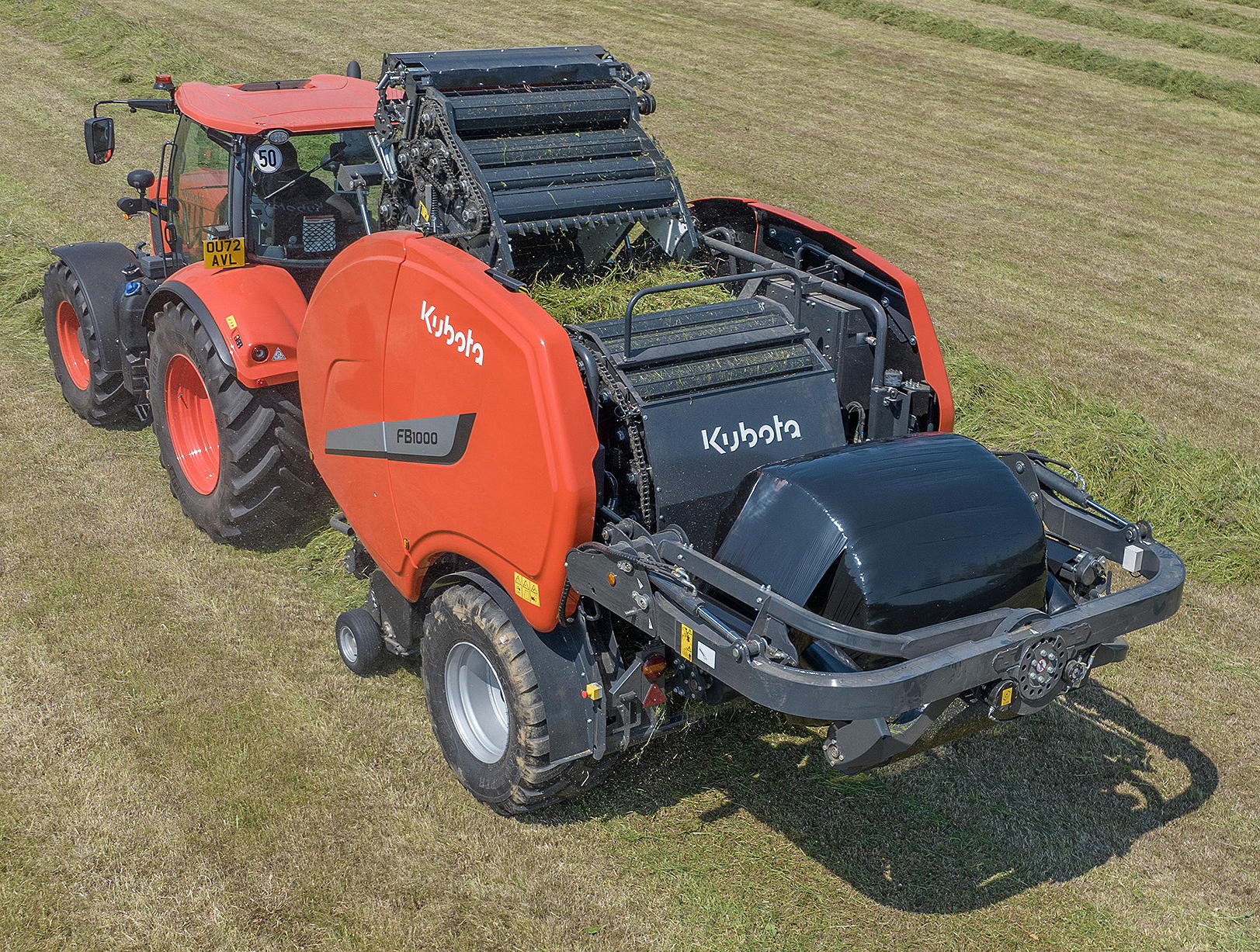 Net is applied to the completed bale in the main chamber on Kubota's FB1000 baler/wrapper. The tailgate is then opened and the finished bale is transferred onto the wrapper.